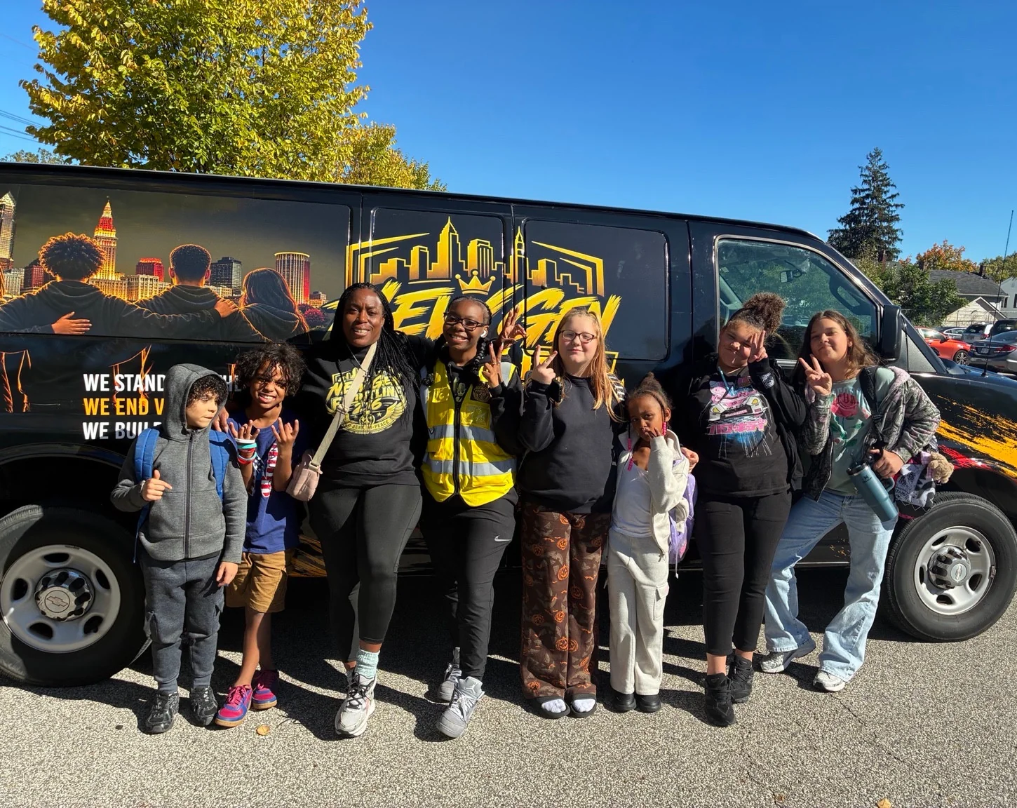 A community group with New Gen team members beside the logo-branded van