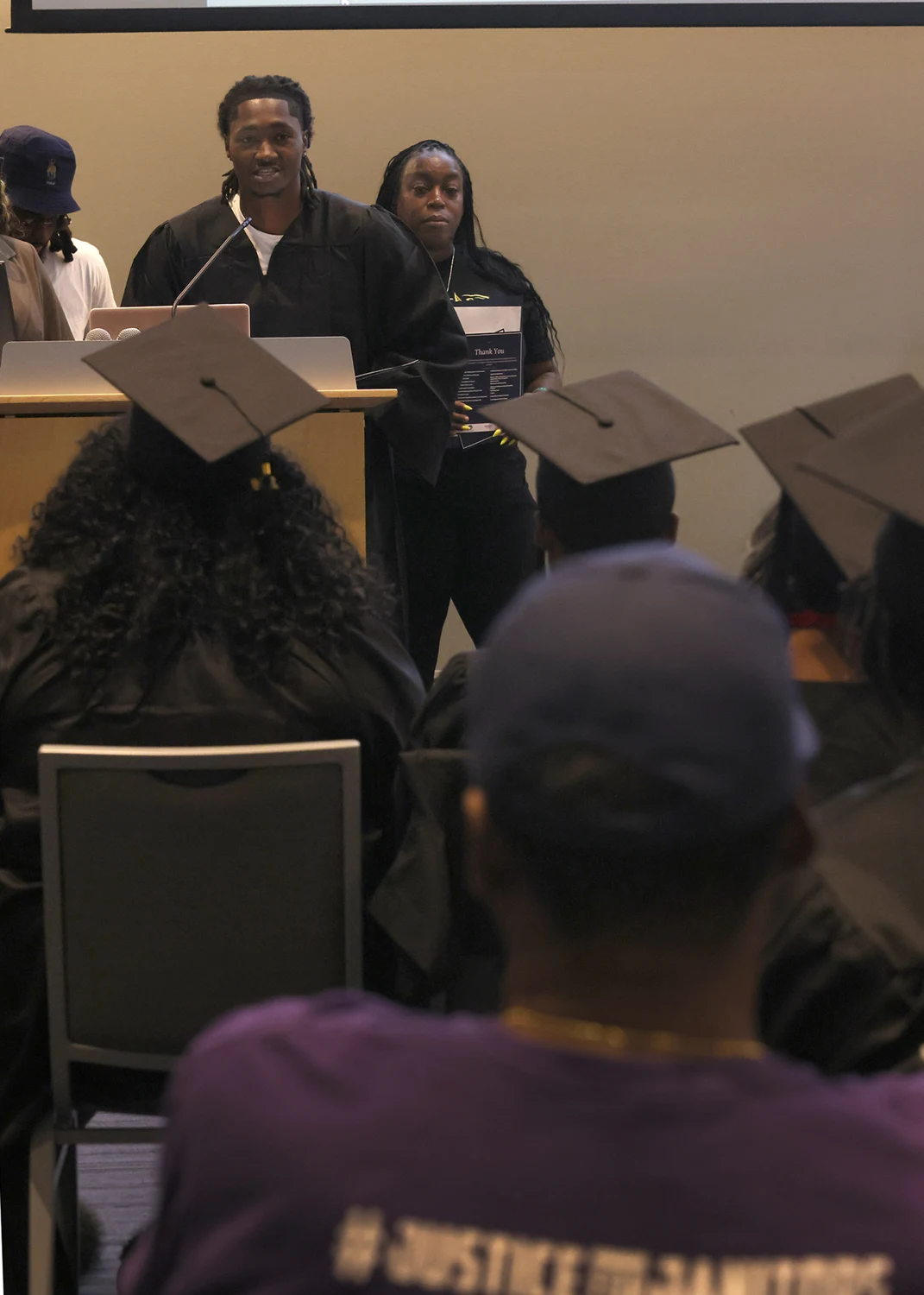 A New Gen graduate speaking at the podium during the graduation ceremony