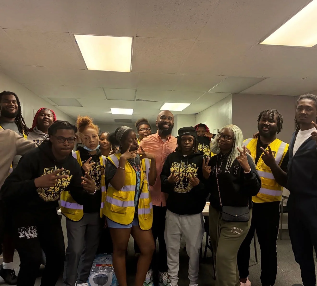 A group indoors wearing New Gen shirts and branded yellow vests